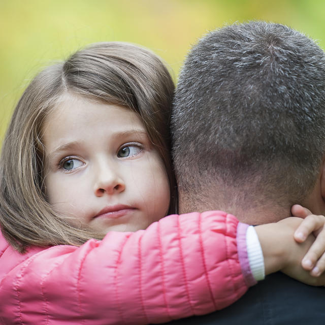 Daughter And Dad Hugging Outdoors