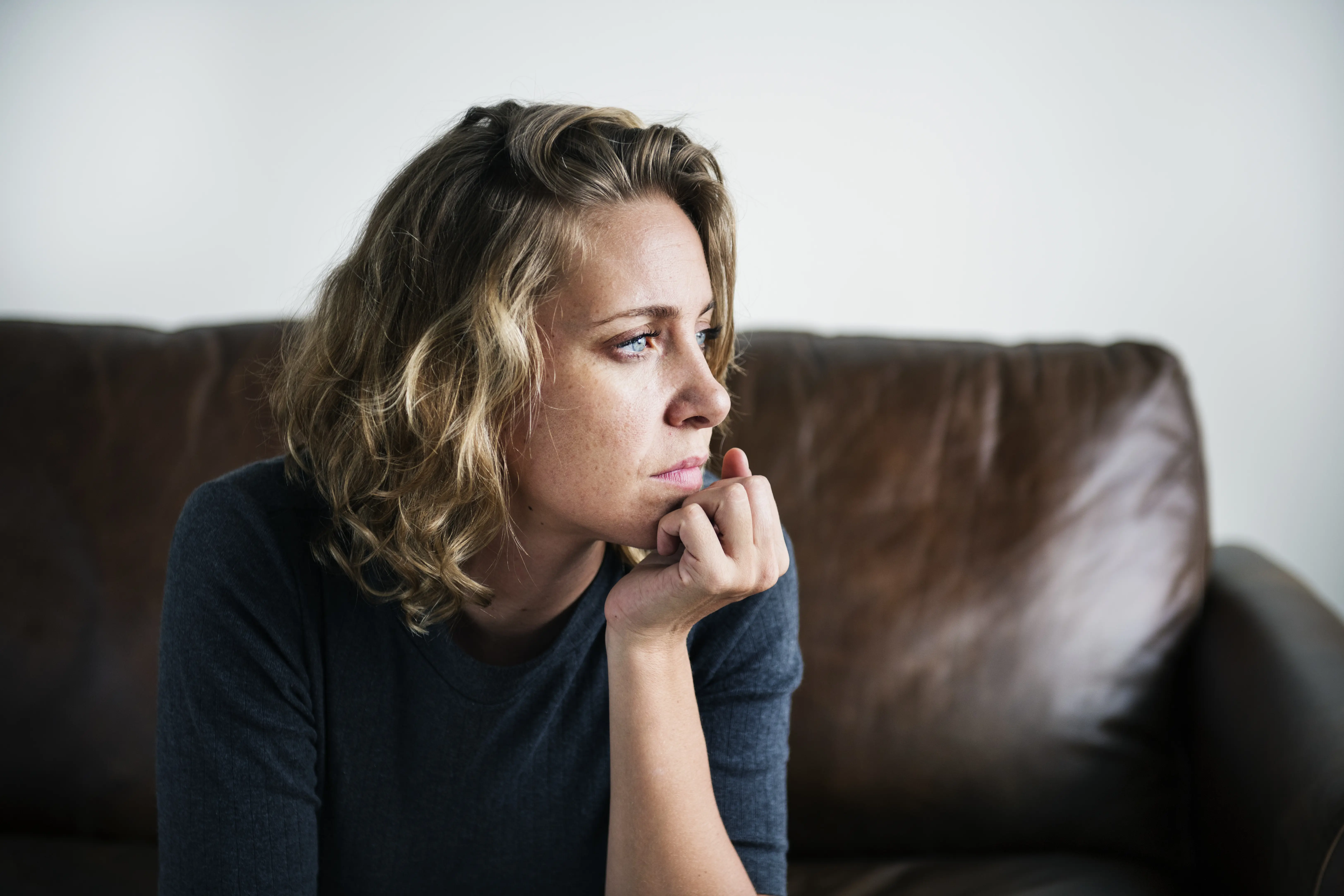 Woman On Sofa Thinking And Looking Away